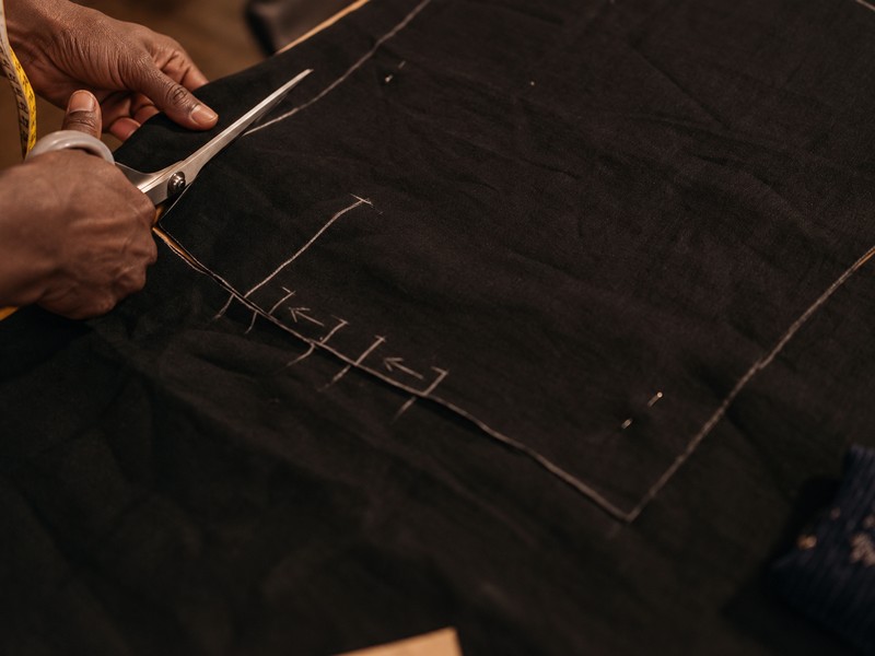 Tailoring shears cutting fabric along a chalk pattern